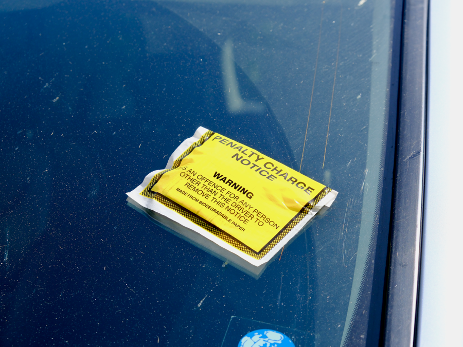 Aviso de deuda colocado sobre el parabrisas de un auto